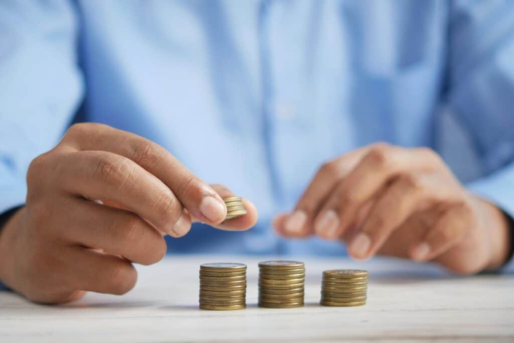 Illustration du budget des ménages antillais fin de mois avec des pièces empilées représentant la gestion des dépenses