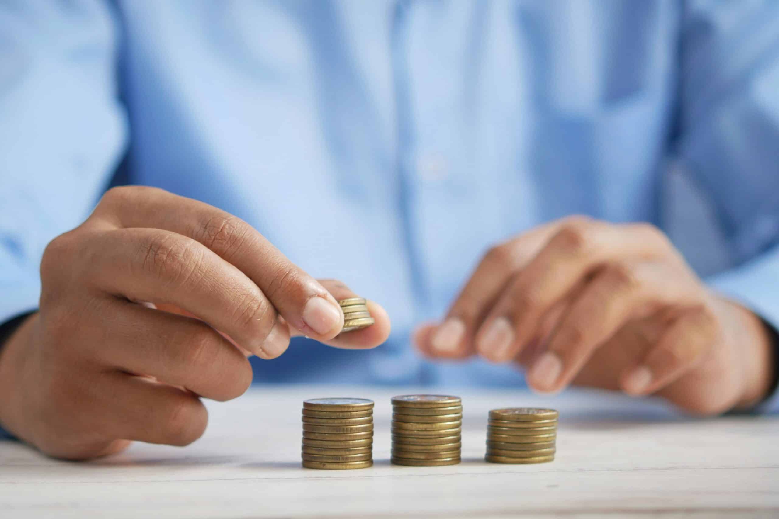 Illustration du budget des ménages antillais fin de mois avec des pièces empilées représentant la gestion des dépenses
