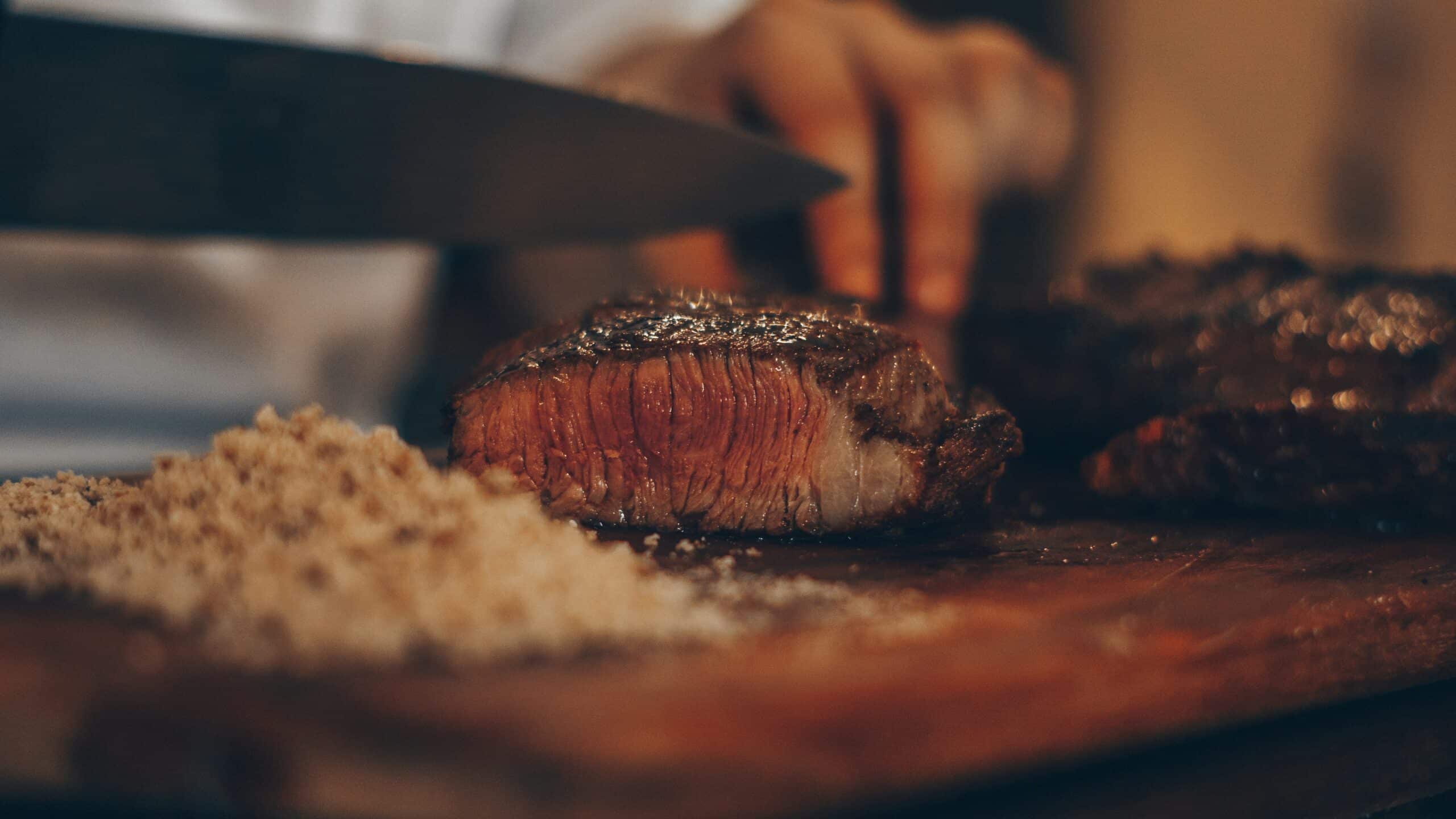 Pièce de bœuf grillée découpée sur une planche en bois dans un restaurant viande Cannes spécialisé dans les viandes d'exception