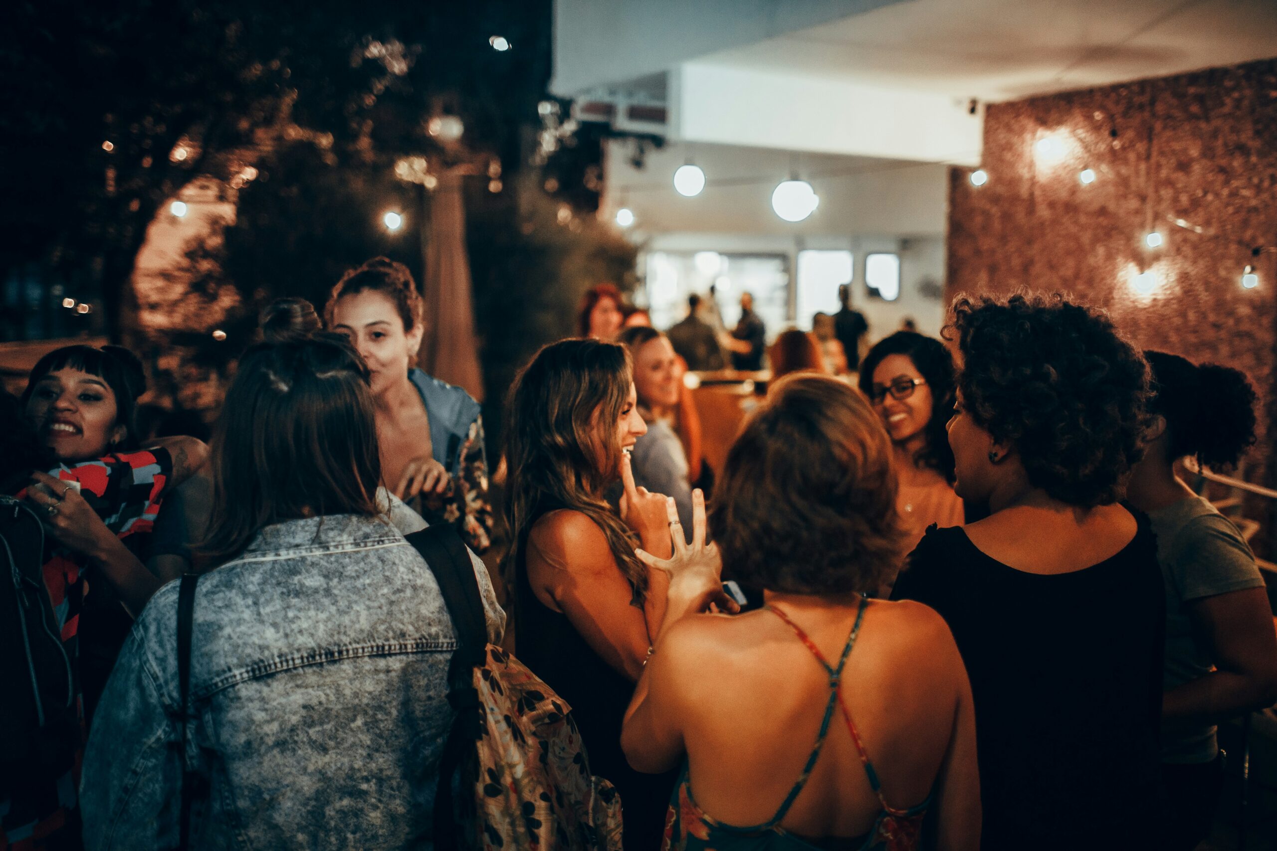 Groupe de personnes échangeant dans une ambiance chaleureuse et festive lors d'une soirée dans un restaurant festif à Cannes avec éclairage tamisé et musique d'ambiance