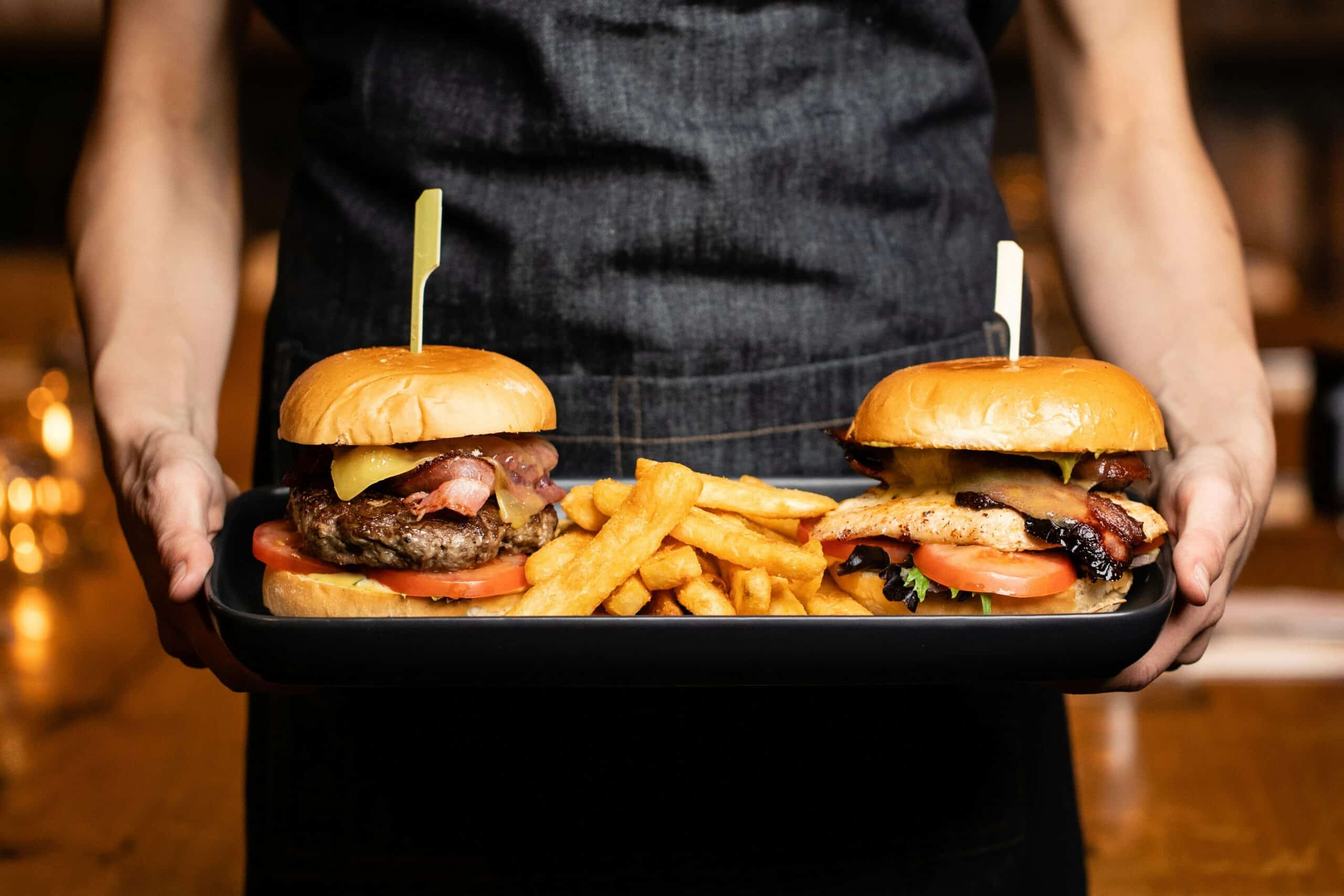 Burger Cannes avec deux burgers gourmets artisanaux, viande grillée, bacon, fromage fondu et frites maison servis sur plateau