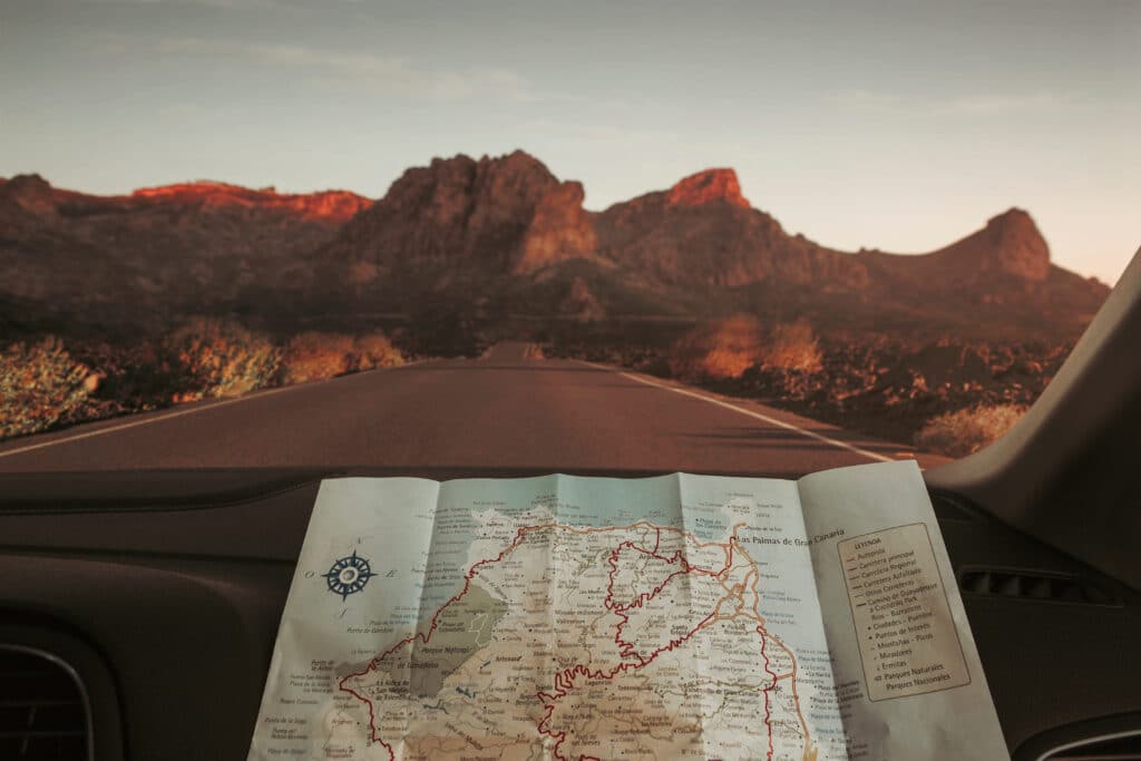 Préparation d’un road trip lors d’un voyage Mexique tout inclus, avec carte routière et route de montagne.